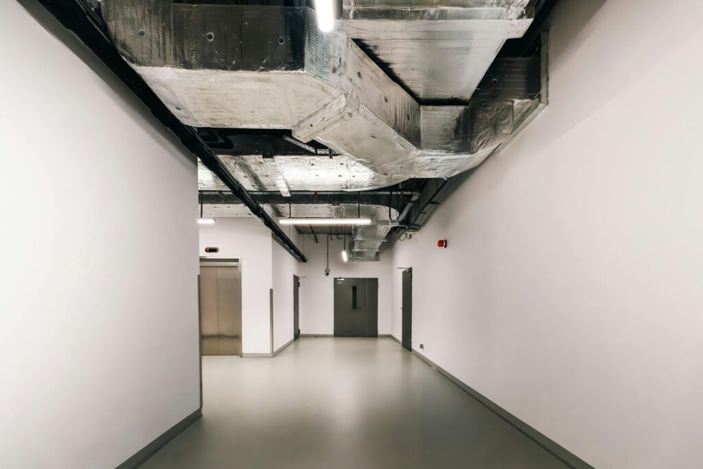 Spacious industrial hallway featuring exposed HVAC ductwork and modern design elements.